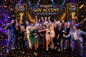 Feestelijke confetti show tijdens een prijsuitreiking met publiek, winnaars en spectaculaire gouden effecten op het podium.
