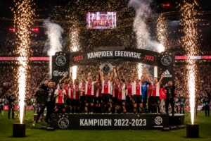 Winnaars op podium met vuurwerkfonteinen tijdens een feestelijke prijsuitreiking en awardshow evenement.